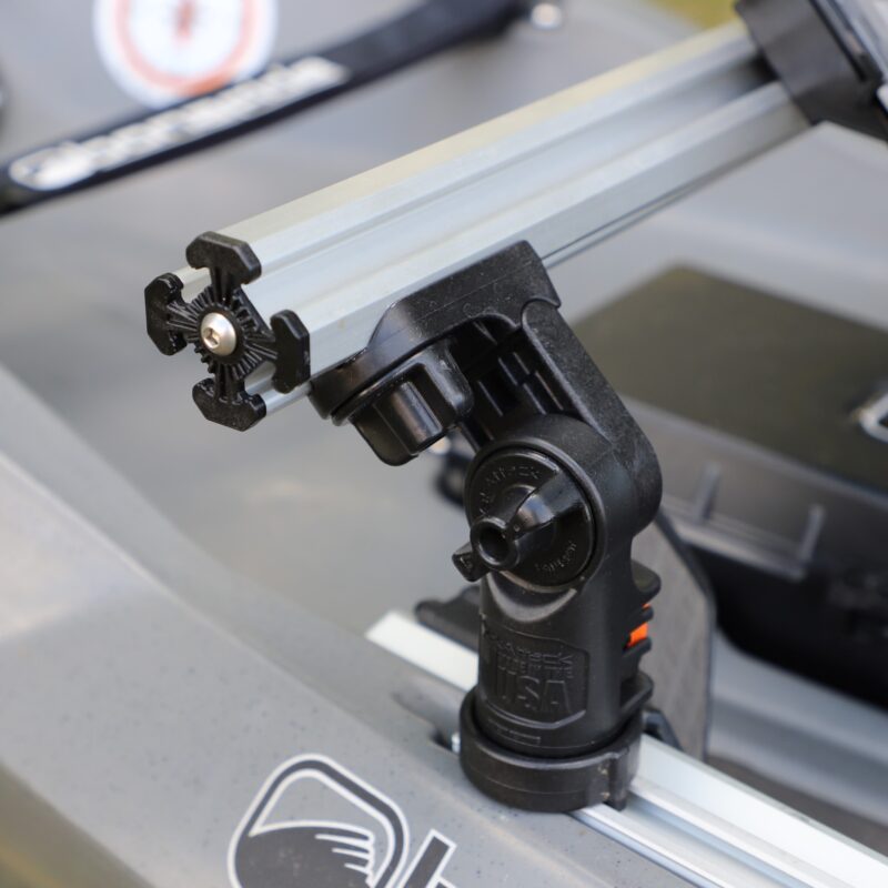 Zbliżenie na pancerną bazę montażową LockNLoad mocującą aluminiową belkę YakAttack do bocznej szyny kajaka wędkarskiego.