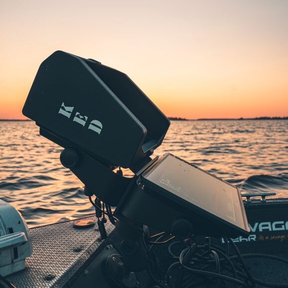 Echosonda Garmin Echomap Ultra z nałożoną osłoną magnetyczną KED zamontowana na konsoli łodzi wędkarskiej w słoneczny dzień