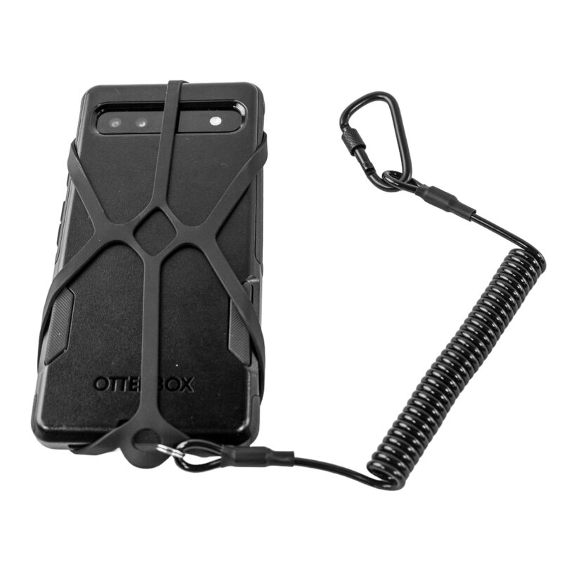 Czarny smartfon w etui OtterBox zabezpieczony elastyczną opaską silikonową YakAttack połączoną ze spiralną smyczą i karabińczykiem na białym tle