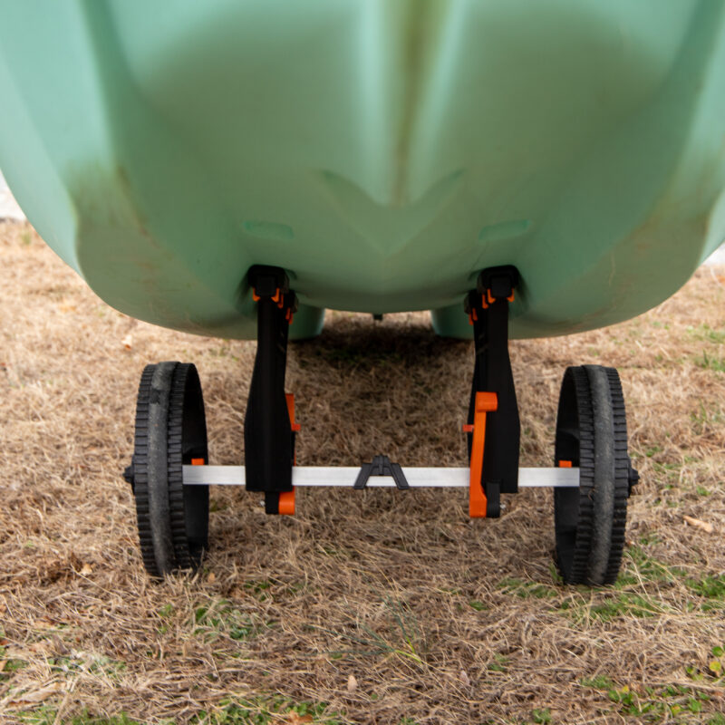 Widok od przodu pod kadłubem miętowego kajaka opierającego się na płozach wózka transportowego YakAttack TowNStow Bunkster Kayak Cart