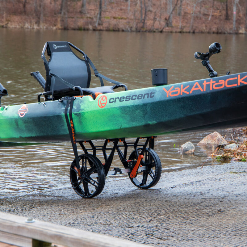 Wózek transportowy do kajaków YakAttack TowNStow Bunkster Kayak Cart podtrzymujący kajak na betonowym slipie wodnym nad jeziorem
