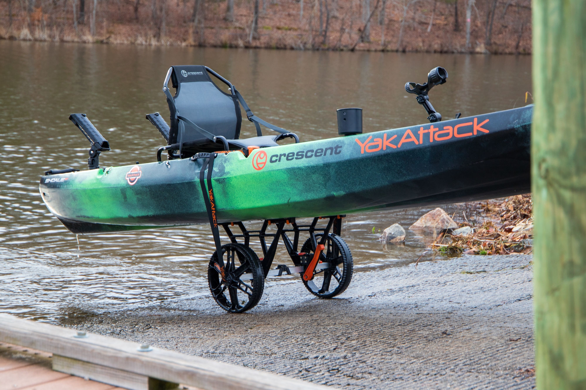 Wózek transportowy do kajaków YakAttack TowNStow Bunkster Kayak Cart podtrzymujący kajak na betonowym slipie wodnym nad jeziorem