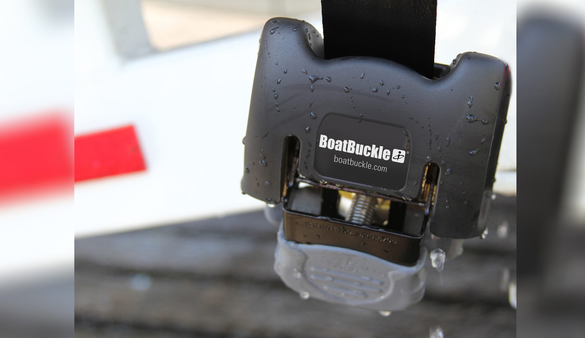 Zbliżenie na stalowy mechanizm zapadkowy i nierdzewny hak automatycznych pasów BoatBuckle SS odpornych na słoną wodę.